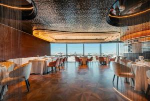 a restaurant with tables and chairs and a large window at Nous Land Beijing in Beijing