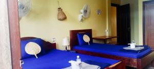 Zimmer mit 2 Betten und blauer Bettwäsche in der Unterkunft Siem Reap Uncle's House in Siem Reap