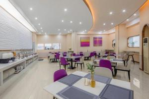 - un restaurant avec des tables et des chaises pourpres dans une pièce dans l'établissement Lavande Hotel Changsha West Jiefang Road Furong Plaza, à Changsha