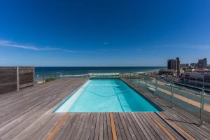 una piscina en la azotea de un edificio con el océano en Stylish 2-Bedroom Sea-View Apartment Horizon Bay Blouberg Beachfront, en Cape Town