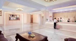 eine Gruppe von Personen, die in einem großen Zimmer stehen in der Unterkunft Vienna Hotel Zhengzhou East High-Speed Railway Station in Zhengzhou