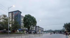 une rue urbaine avec des bâtiments et une rue avec des voitures dans l'établissement Vienna Hotel Shenzhen Pingdi Huancheng South Road, à Longgang