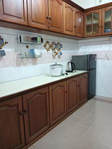 a kitchen with wooden cabinets and a refrigerator at CD Homestay 
