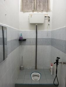 a bathroom with a toilet in a tiled floor at CD Homestay 