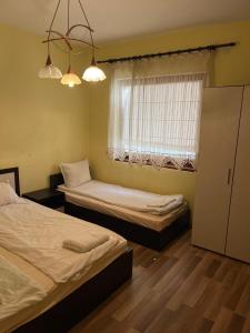 a bedroom with two beds and a window at Country House БатЖоро 