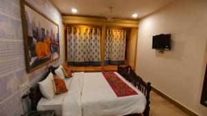 a bedroom with a bed and a television in it at Kiran Apartment By Experience Jaisalmer in Jaisalmer