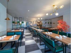 a dining room with wooden tables and green chairs at Vienna Hotel Nanning Anji Wanda 33rd Middle School Metro Station in Nanning