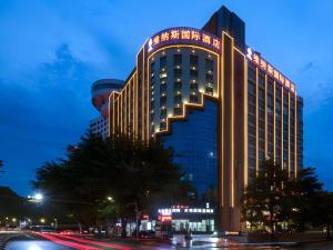 Un grand bâtiment avec des lumières allumées la nuit dans l'établissement Venus International Hotel Guangdong Huizhou West Lake, à Huizhou