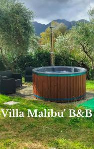 a wooden hot tub in a yard with a garden at Villa - Malibu' B & B in Lauria