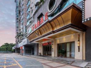 a building with a sign on the side of a street at Vienna Hotel Shenzhen Window of the World Qiaochengdong Metro Station in Shenzhen
