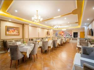 a restaurant with tables and chairs in a room at Vienna Hotel Tianjin Zhongbei Town in Tianjin
