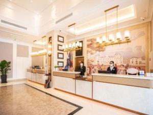 a lobby of a restaurant with people sitting at a counter at Vienna Hotel Tianjin Jinzhong Street in Tianjin