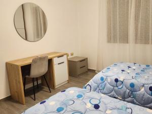 a bedroom with a bed and a desk and a mirror at Albert's house for rent in Vlorë