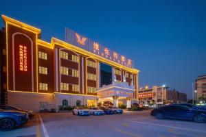 a large building with cars parked in a parking lot at Vienna Hotel Guangdong Foshan Wenhua North Road in Nanhai