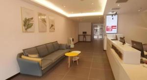 un salon avec un canapé et une table dans l'établissement Green Tree Inn Liaoning Shenfu New District, à Mantangmanzuxiang 23 autres photos