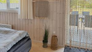 - une chambre avec un lit et une fenêtre avec une plante dans l'établissement Vakantiehuis Vlakbij Zee En Gezellig Sæby, à Sæby