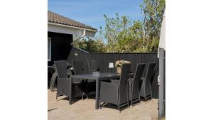 un patio avec une table et des chaises et une clôture dans l'établissement Vakantiehuis Vlakbij Zee En Gezellig Sæby, à Sæby 33 autres photos