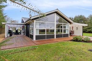 a house with a deck and large windows at Lovely Holiday Home By The Limfjord in Storvorde