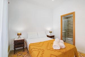 a bedroom with a bed with two towels on it at Quinta Alegre Tavira Moderno T2 in Luz de Tavira