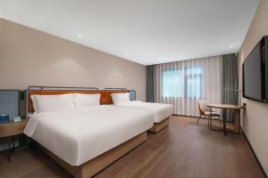 a bedroom with a large white bed and a television at Echarm Hotel Nanjing Expo Center Olympic East Metro Station in Nanjing +238 photos