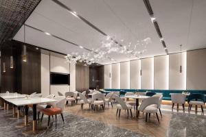 太原市にあるAtour Hotel Taiyuan Inner Ringのテーブルと椅子とテレビのあるダイニングルーム