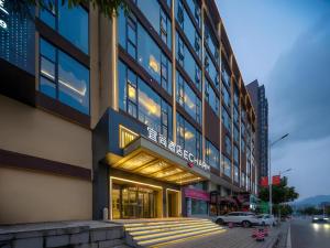 a building on a street with a car parked in front at Echarm Hotel Zhangjiajie Tianmen Mountain High-speed Railway Station in Zhangjiajie