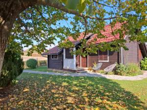a house with two chairs in the yard at Apartment Golden Fields in Smoljanac