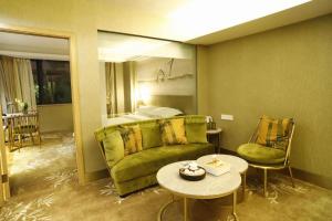 a room with a couch and a bed and a table at 翠竹酒店(深圳东门城景中心店) in Shenzhen