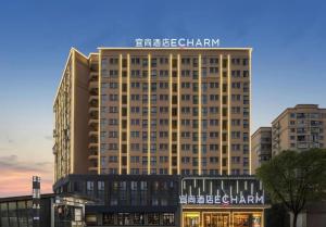 a large building with a sign on top of it at Echarm Hotel Changsha Huanghua Airport in Gutang