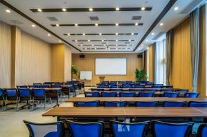 an empty lecture hall with tables and chairs at Borrman Hotel Zhangzhou Baolong Plaza in Zhangzhou
