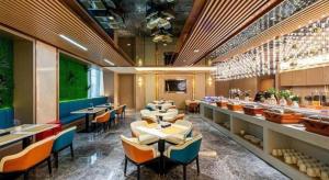 a restaurant with tables and chairs in a room at Borrman Hotel Zhongshan Lihe Plaza in Zhongshan