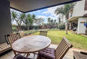 - une table et des chaises sur une terrasse avec vue sur la cour dans l'établissement Royal Park Resort & Villas, à Arsenal