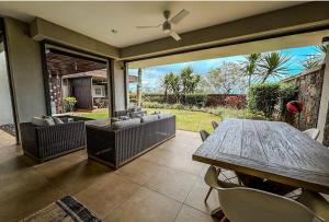 un patio avec une table, des chaises et un canapé dans l'établissement Royal Park Resort & Villas, à Arsenal