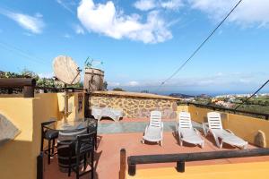 Santa Maria de GuiaにあるHogar vacacional Taluの建物の上にテーブルと椅子が置かれたバルコニー