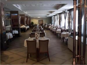 uma sala de jantar com mesas e cadeiras em um restaurante em Shenzhen Nan Fei Yuan Hotel em Shenzhen