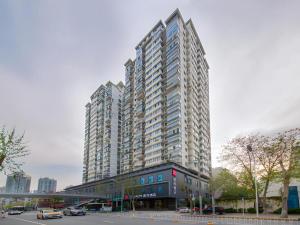 un gran edificio alto en una ciudad con una calle en Echarm Hotel Wuhan Hankou Railway Station Zhuyeshan Metro Station, en Wuhan
