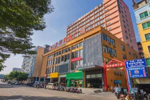 a city street with tall buildings and parked motorcycles at City Comfort Premier Hotel Nanning Guangxi University Zoo Metro Station in Nanning
