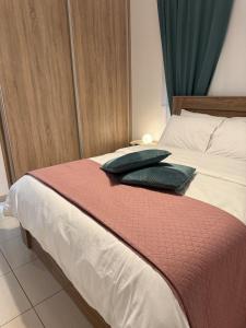 een slaapkamer met een bed met twee kussens erop bij Abitare Retreat in Paphos City +8 foto's