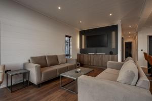 a living room with a couch and a flat screen tv at Lodge No 147 - Stewarts Resort Cameron in Cameron