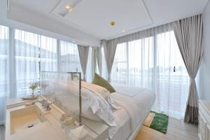 a bedroom with a large bed and large windows at Riva Arun Bangkok in Bangkok