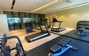 a gym with several treadmills and cardio machines at Echarm Hotel Shenzhen World Exhibition and Convention Center in Fenghuangwei