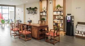 a dining room with a table and chairs and a refrigerator at Green Tree Inn Tianjin Jinnan Linshijun University of Finance and Economics in Tianjin