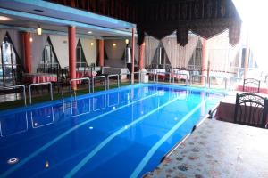 a large swimming pool with chairs and tables at Kabul Blue Star Guest House Number 2 in Kabul