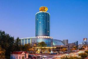 a tall building with a face on the top of it at Vienna Hotel Tianjin Olympic Sports Center Tianta in Tianjin
