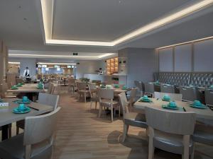 a restaurant with tables and chairs and a chef in the background at Best Sleep International Hotel Shenzhen Tanglang Metro Station in Shenzhen