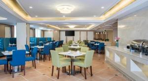a dining room with tables and blue chairs at Vienna Hotel Guangzhou Baiyun Airport Huadu Avenue in Huadu