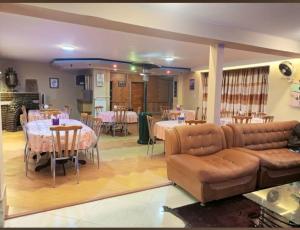a living room with a couch and tables and chairs at Kabul Blue Star Guest House Number 2 in Kabul