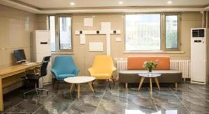 北京市にあるGreen Tree Inn Beijing Daxing District Jiugong Hospitalの椅子とソファと机のあるオフィス