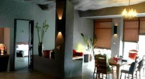 une chambre avec une table à manger et une chambre dans l'établissement Avartarn Miracles Hotel, à Ban Soi Rakhlong