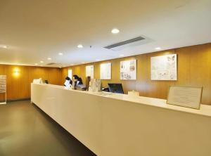 un hall d'entrée avec un comptoir avec des gens assis devant des ordinateurs dans l'établissement Caritas Oswald Cheung International House, à Hong Kong